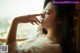 A woman in a white dress sitting on a window sill.