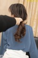 A woman is getting her hair styled by a hairdresser.