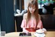 A woman sitting at a table with a cup of coffee and a tablet.