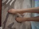 A person's feet on a rug with a handprint on it.