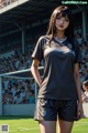 A woman standing on a soccer field in front of a crowd.