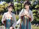 A couple of women standing next to each other in a park.