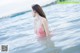 A woman in a pink bikini standing in the water.