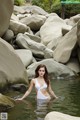 A woman in a white bikini standing in the water.