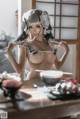 A woman in lingerie sitting at a table with chopsticks.