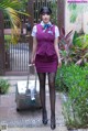 A woman in a purple uniform with a suitcase.