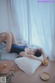 A woman laying on a pillow with a lemon in her hand.