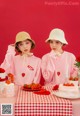 A couple of women sitting at a table with a cake.