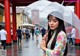 A woman in a floral dress holding an umbrella.