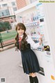 A woman standing in front of a vending machine.