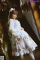 A woman in a blue and white dress standing on a staircase.