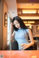 A woman sitting at a table with a glass of water.