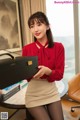 a woman in a red shirt and skirt holding a briefcase