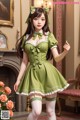 A woman in a green dress holding a flower.