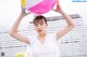 A woman holding a large pink and yellow beach ball.