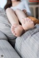 A woman sitting on a couch with her feet up.