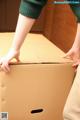 A person is opening a cardboard box with their hands.