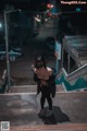 A woman wearing a mask standing on a stairway at night.