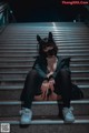 A woman wearing a cat mask sitting on some stairs.