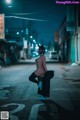 A naked woman standing in the middle of a street at night.