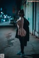 A woman wearing a mask standing in the middle of a street.