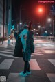 A woman wearing a mask standing in the middle of a street.