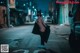 A woman wearing a mask standing in the middle of a street.