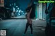 A naked woman standing in the middle of a street at night.