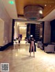 A naked woman standing in the lobby of a hotel.