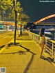 A woman walking down a sidewalk next to a body of water.