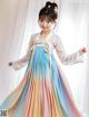 A little girl wearing a colorful hanbok is posing for a picture.