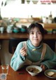 A woman sitting at a table with a bowl of soup.