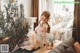 a woman sitting on top of a couch next to a plant