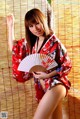A woman in a red kimono holding a fan.