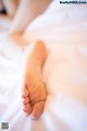 A close up of a person's foot on a bed.