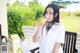 A woman sitting at a table drinking orange juice.