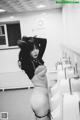 A black and white photo of a woman in a public restroom.