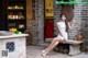 A woman in a white dress sitting on a bench.