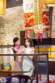 A couple of women standing next to each other in a restaurant.