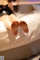 A woman laying on a bed with her feet up.